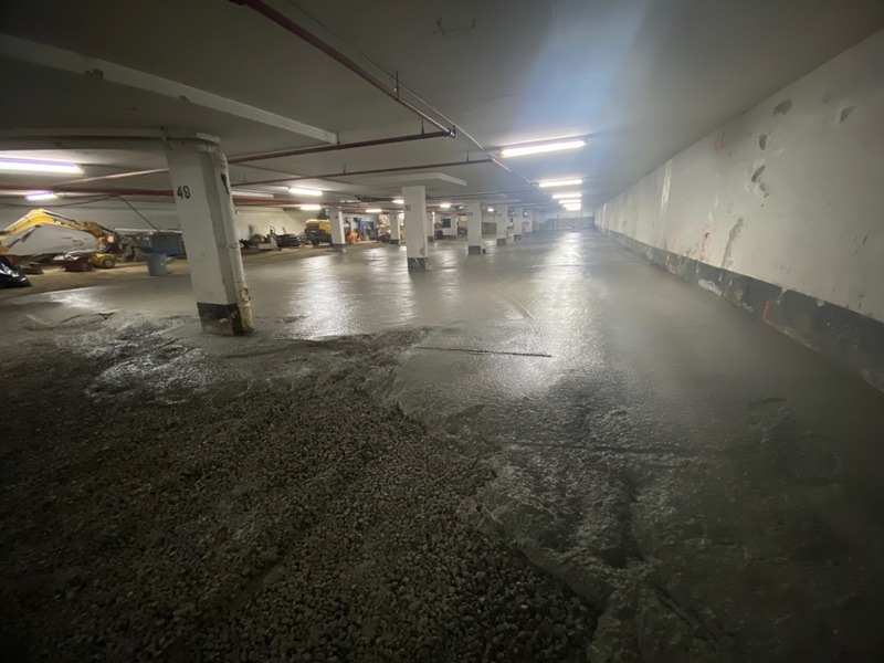 Concrete flooring work underway in an underground parking garage